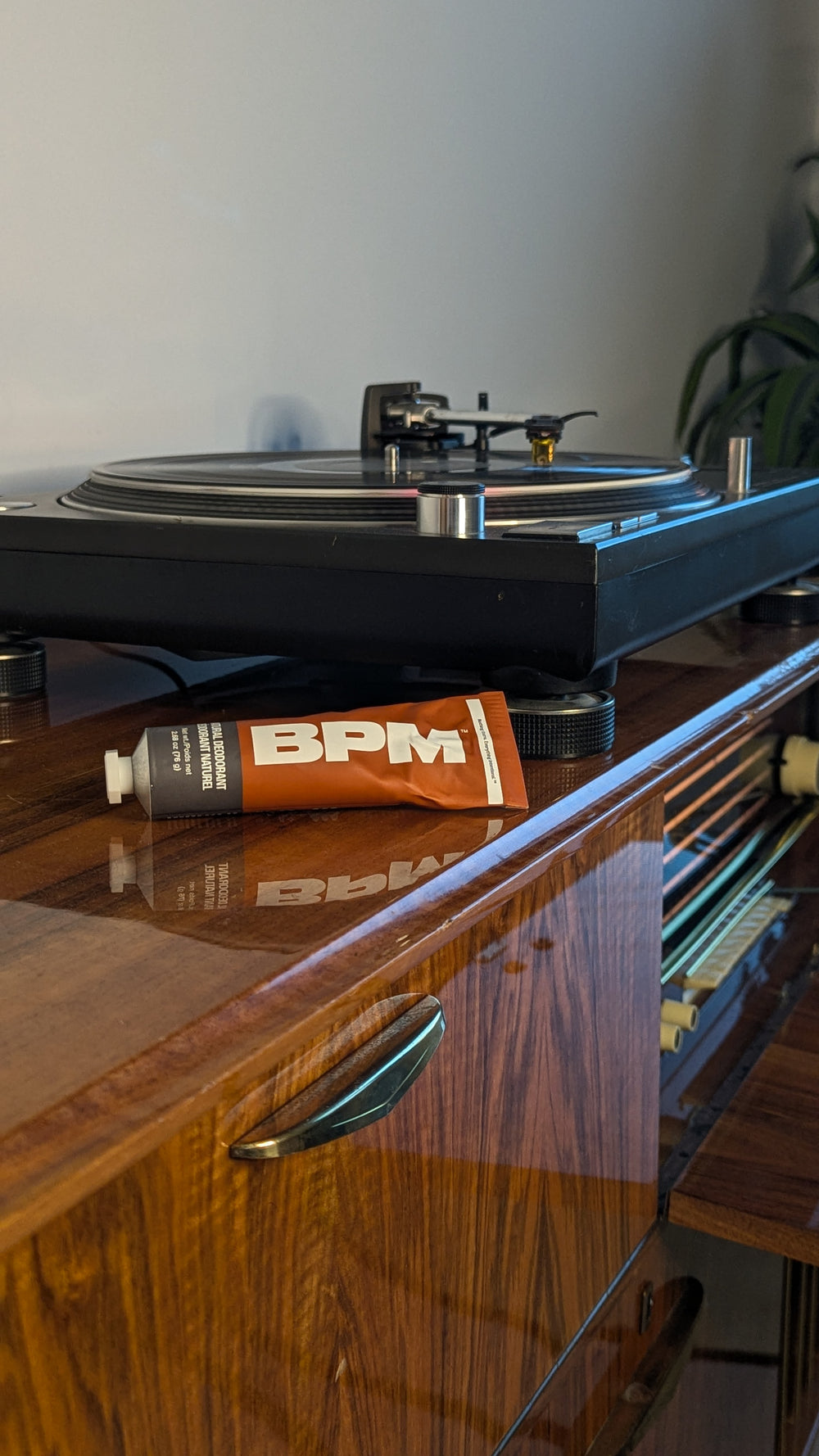Turntable on a wooden surface with a used tube of BPM deodorant