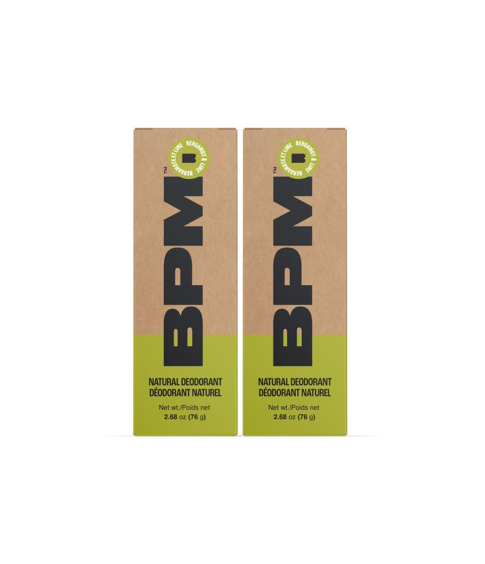 Two rectangular BPM natural deodorant boxes standing upright on a white background. The packaging is kraft brown with a bright yellow-green band at the bottom and large black BPM lettering.