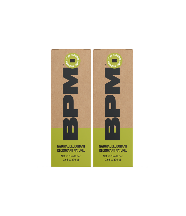 Two rectangular BPM natural deodorant boxes standing upright on a white background. The packaging is kraft brown with a bright yellow-green band at the bottom and large black BPM lettering.